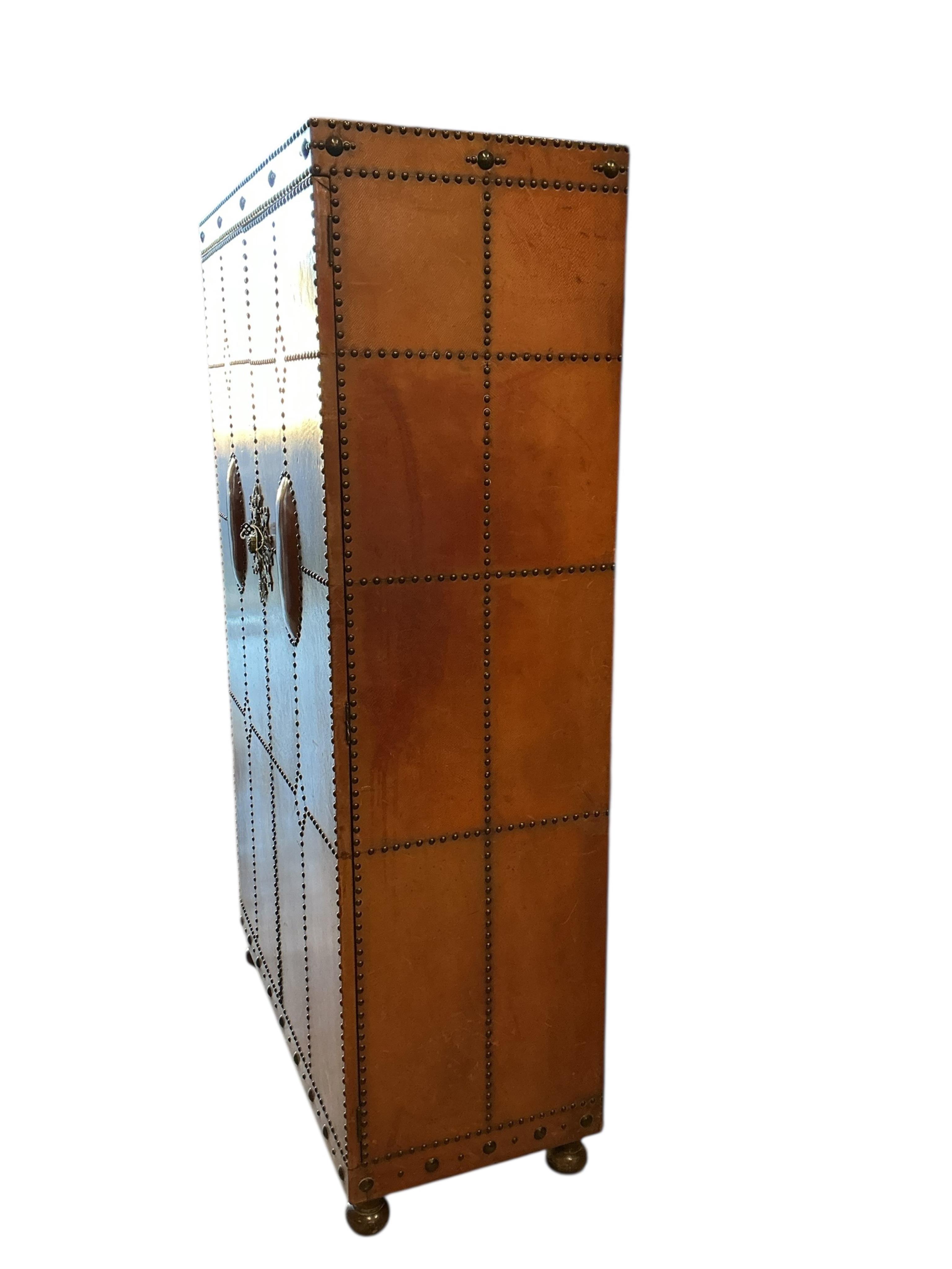 An early 20th century Spanish style studded, tan leather covered two door wardrobe, width 96cm, depth 46cm, height 168cm